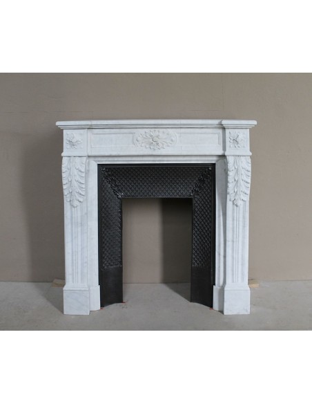 Neoclassical "Trois Fleurs" fireplace mantel in white marble with cast iron insert, small size and rich decorative detailing.