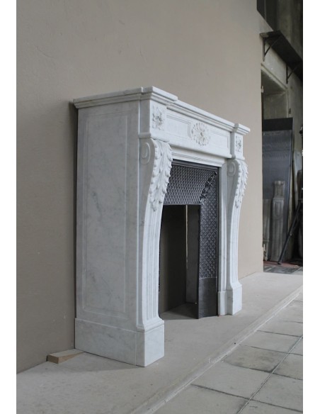 Neoclassical "Trois Fleurs" fireplace mantel in white marble with cast iron insert, small size and rich decorative detailing.