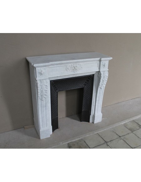 Neoclassical "Trois Fleurs" fireplace mantel in white marble with cast iron insert, small size and rich decorative detailing.