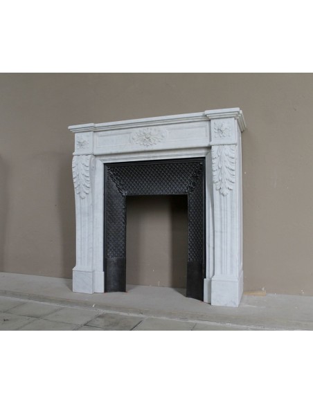 Neoclassical "Trois Fleurs" fireplace mantel in white marble with cast iron insert, small size and rich decorative detailing.