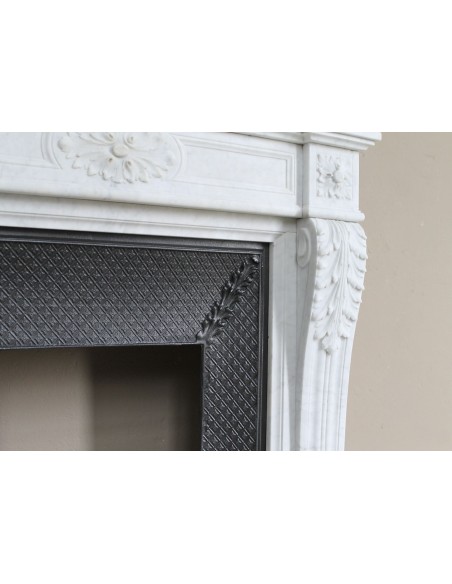 Neoclassical "Trois Fleurs" fireplace mantel in white marble with cast iron insert, small size and rich decorative detailing.