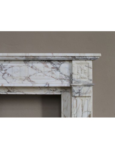 Small and lovely antique Neoclassical fireplace mantel in Calacatta Gold marble, with floral decorations and fluted detailing.