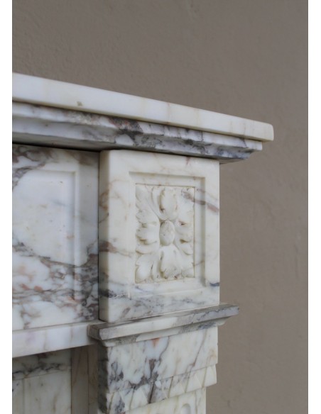 Small and lovely antique Neoclassical fireplace mantel in Calacatta Gold marble, with floral decorations and fluted detailing.