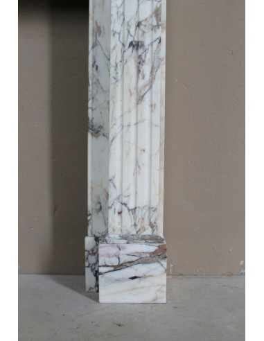 Small and lovely antique Neoclassical fireplace mantel in Calacatta Gold marble, with floral decorations and fluted detailing.