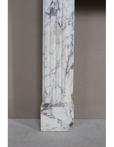 Small and lovely antique Neoclassical fireplace mantel in Calacatta Gold marble, with floral decorations and fluted detailing.