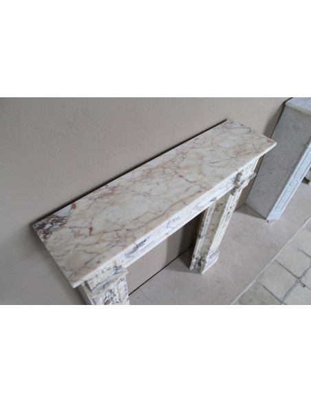 Small and lovely antique Neoclassical fireplace mantel in Calacatta Gold marble, with floral decorations and fluted detailing.