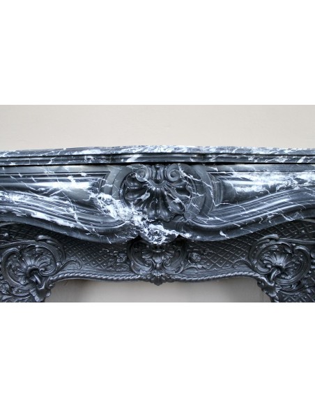 Antique Baroque-style fireplace mantel carved in black Marquinia marble with white veining, with its original cast iron insert.
