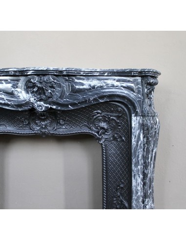 Antique Baroque-style fireplace mantel carved in black Marquinia marble with white veining, with its original cast iron insert.