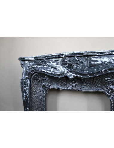 Antique Baroque-style fireplace mantel carved in black Marquinia marble with white veining, with its original cast iron insert.