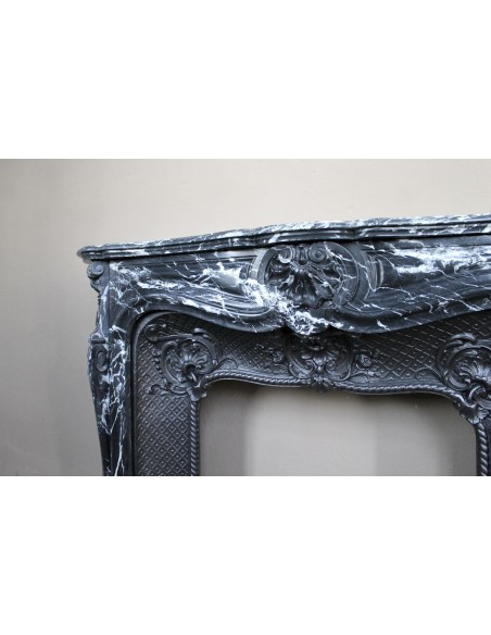 Antique Baroque-style fireplace mantel carved in black Marquinia marble with white veining, with its original cast iron insert.