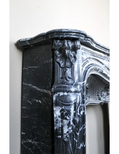 Antique Baroque-style fireplace mantel carved in black Marquinia marble with white veining, with its original cast iron insert.