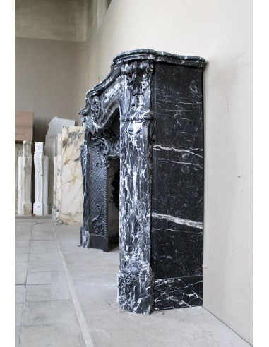 Antique Baroque-style fireplace mantel carved in black Marquinia marble with white veining, with its original cast iron insert.