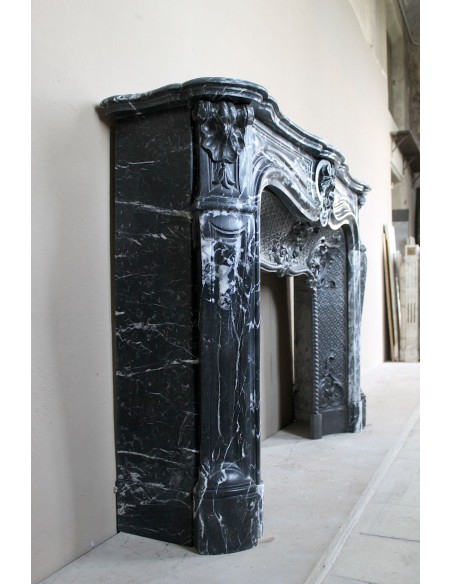 Antique Baroque-style fireplace mantel carved in black Marquinia marble with white veining, with its original cast iron insert.