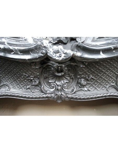 Antique Baroque-style fireplace mantel carved in black Marquinia marble with white veining, with its original cast iron insert.