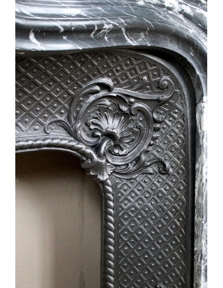 Antique Baroque-style fireplace mantel carved in black Marquinia marble with white veining, with its original cast iron insert.