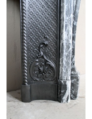 Antique Baroque-style fireplace mantel carved in black Marquinia marble with white veining, with its original cast iron insert.
