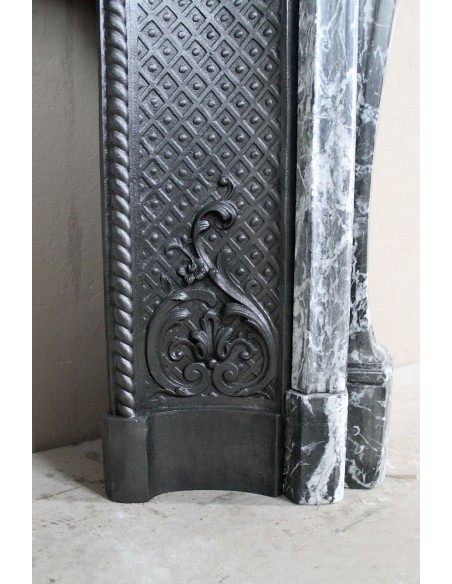 Antique Baroque-style fireplace mantel carved in black Marquinia marble with white veining, with its original cast iron insert.