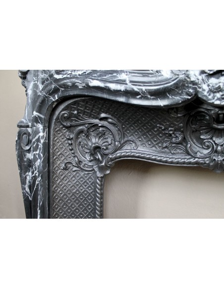 Antique Baroque-style fireplace mantel carved in black Marquinia marble with white veining, with its original cast iron insert.
