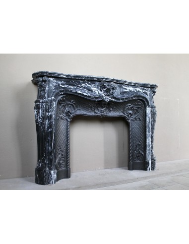 Antique Baroque-style fireplace mantel carved in black Marquinia marble with white veining, with its original cast iron insert.