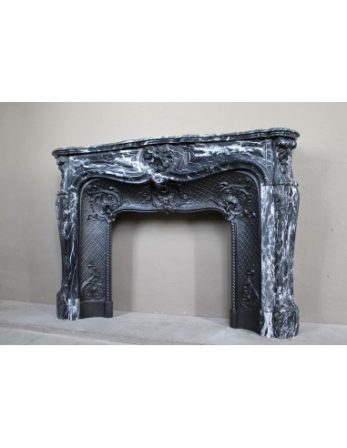 Antique Baroque-style fireplace mantel carved in black Marquinia marble with white veining, with its original cast iron insert.