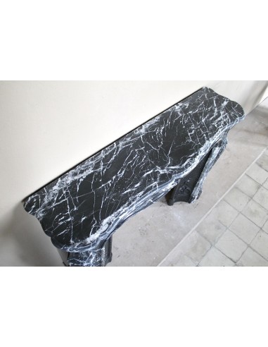 Antique Baroque-style fireplace mantel carved in black Marquinia marble with white veining, with its original cast iron insert.
