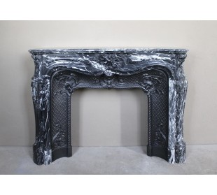 Antique Baroque-style fireplace mantel carved in black Marquinia marble with white veining, with its original cast iron insert.