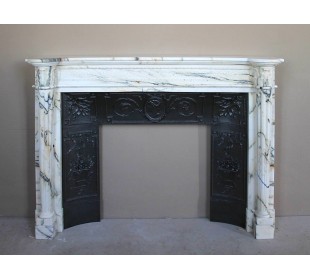 Rare and refined Neoclassical “Macaron” fireplace mantel with floral sculptural elements, perlage detailing, and column motifs.