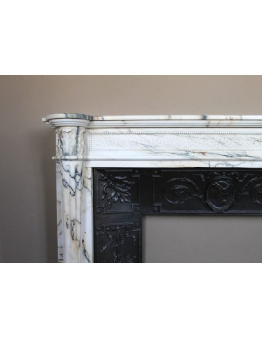 Rare and refined Neoclassical “Macaron” fireplace mantel with floral sculptural elements, perlage detailing, and column motifs.