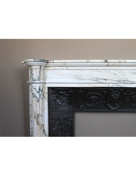 Rare and refined Neoclassical “Macaron” fireplace mantel with floral sculptural elements, perlage detailing, and column motifs.