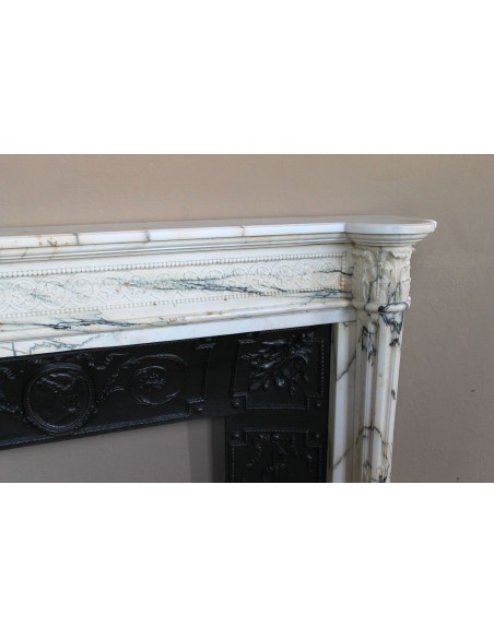 Rare and refined Neoclassical “Macaron” fireplace mantel with floral sculptural elements, perlage detailing, and column motifs.