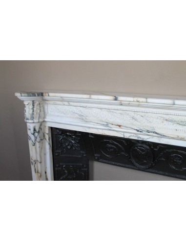 Rare and refined Neoclassical “Macaron” fireplace mantel with floral sculptural elements, perlage detailing, and column motifs.