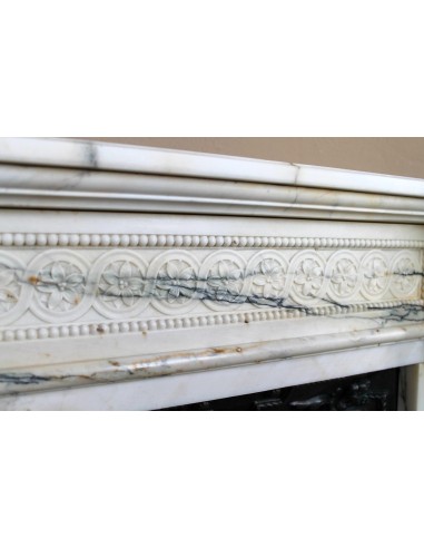 Rare and refined Neoclassical “Macaron” fireplace mantel with floral sculptural elements, perlage detailing, and column motifs.
