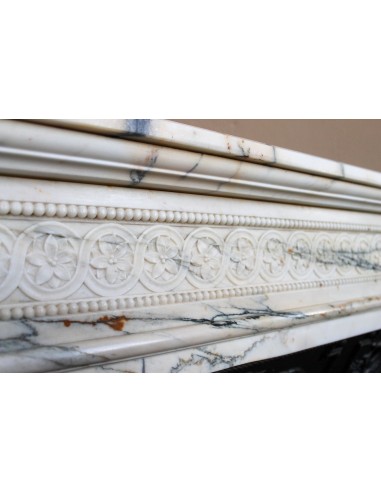 Rare and refined Neoclassical “Macaron” fireplace mantel with floral sculptural elements, perlage detailing, and column motifs.