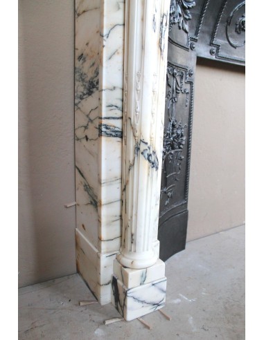 Rare and refined Neoclassical “Macaron” fireplace mantel with floral sculptural elements, perlage detailing, and column motifs.