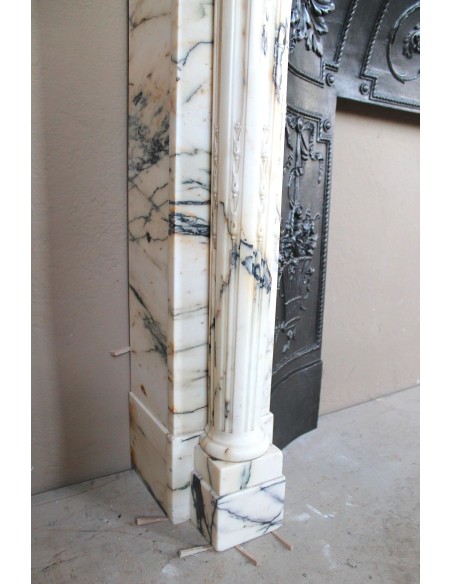 Rare and refined Neoclassical “Macaron” fireplace mantel with floral sculptural elements, perlage detailing, and column motifs.