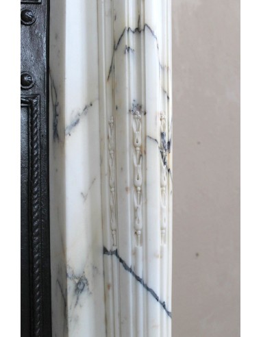 Rare and refined Neoclassical “Macaron” fireplace mantel with floral sculptural elements, perlage detailing, and column motifs.