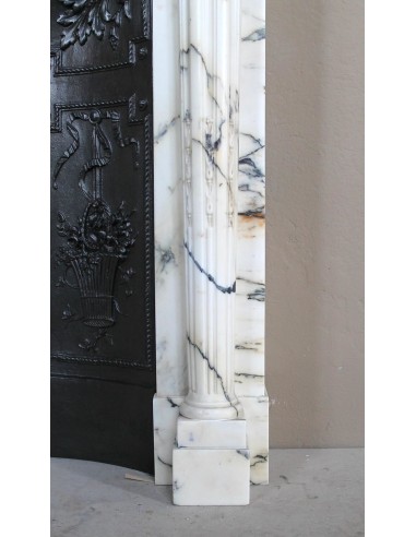 Rare and refined Neoclassical “Macaron” fireplace mantel with floral sculptural elements, perlage detailing, and column motifs.