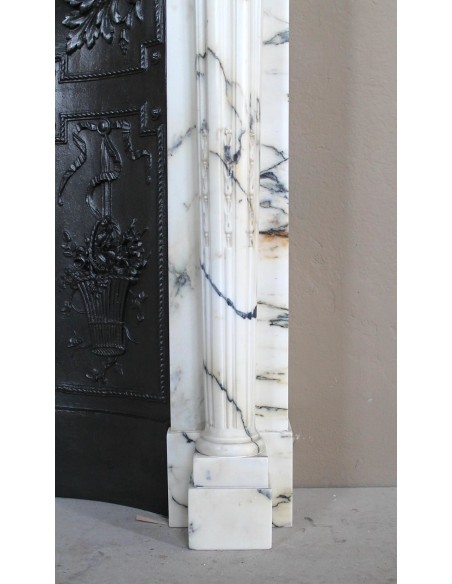 Rare and refined Neoclassical “Macaron” fireplace mantel with floral sculptural elements, perlage detailing, and column motifs.