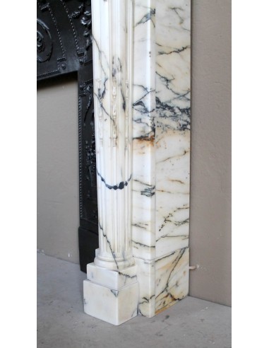 Rare and refined Neoclassical “Macaron” fireplace mantel with floral sculptural elements, perlage detailing, and column motifs.