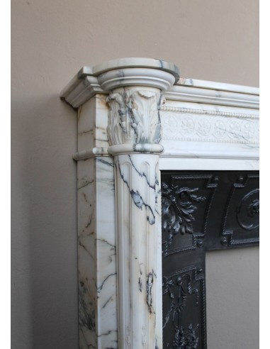 Rare and refined Neoclassical “Macaron” fireplace mantel with floral sculptural elements, perlage detailing, and column motifs.