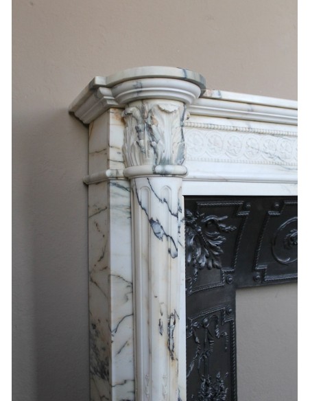 Rare and refined Neoclassical “Macaron” fireplace mantel with floral sculptural elements, perlage detailing, and column motifs.