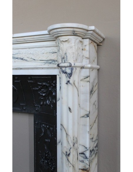 Rare and refined Neoclassical “Macaron” fireplace mantel with floral sculptural elements, perlage detailing, and column motifs.
