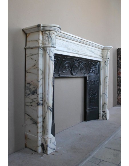 Rare and refined Neoclassical “Macaron” fireplace mantel with floral sculptural elements, perlage detailing, and column motifs.