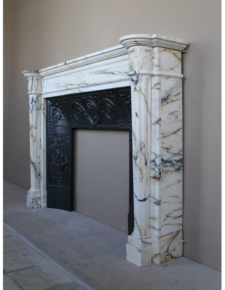 Rare and refined Neoclassical “Macaron” fireplace mantel with floral sculptural elements, perlage detailing, and column motifs.