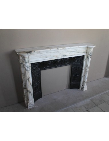 Rare and refined Neoclassical “Macaron” fireplace mantel with floral sculptural elements, perlage detailing, and column motifs.