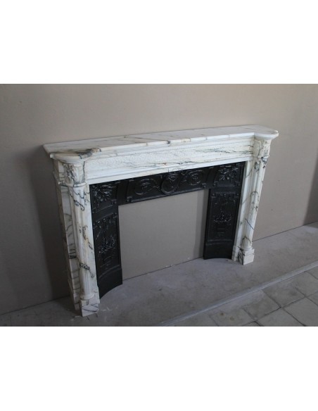 Rare and refined Neoclassical “Macaron” fireplace mantel with floral sculptural elements, perlage detailing, and column motifs.