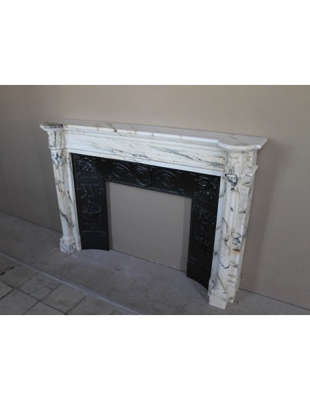 Rare and refined Neoclassical “Macaron” fireplace mantel with floral sculptural elements, perlage detailing, and column motifs.