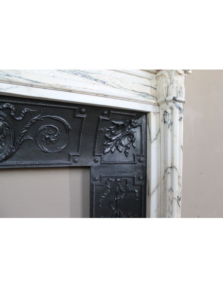 Rare and refined Neoclassical “Macaron” fireplace mantel with floral sculptural elements, perlage detailing, and column motifs.