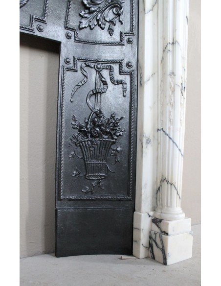 Rare and refined Neoclassical “Macaron” fireplace mantel with floral sculptural elements, perlage detailing, and column motifs.