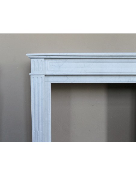 Louis XVI “Cannelure” fireplace mantel carved in “Pure” Bianco Carrara marble. A sober, elegant, and linear antique fireplace.